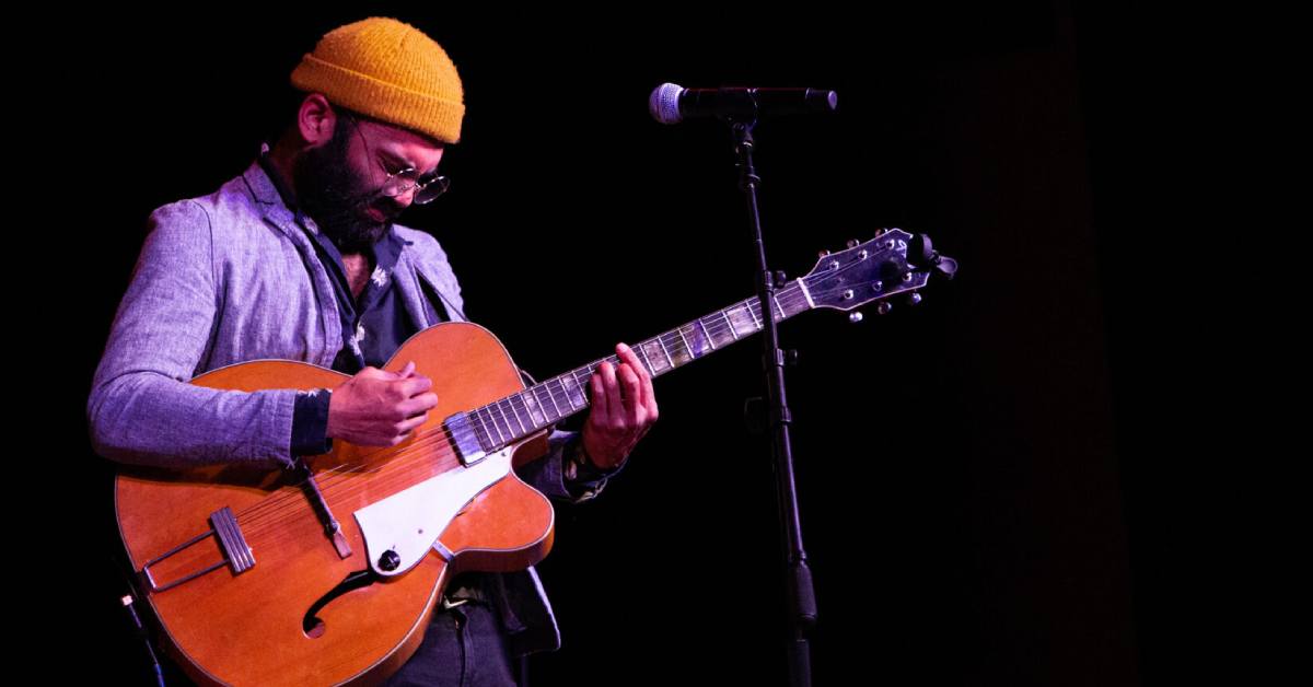 man on guitar on stage