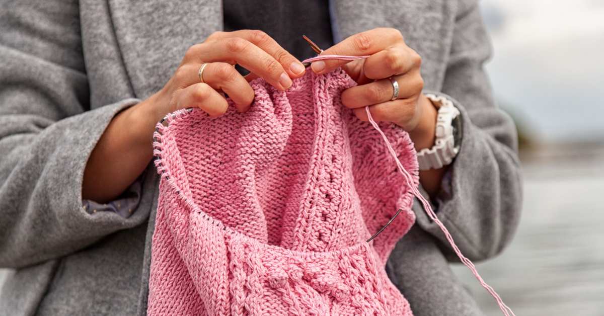 woman crocheting pink item