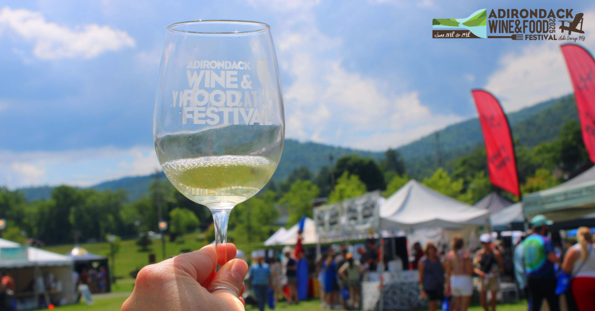 glass of white wine held up against festival