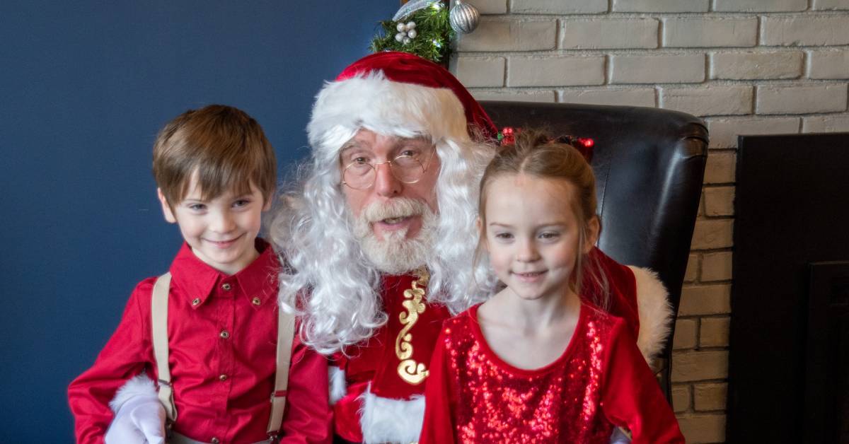 two kids pose with santa