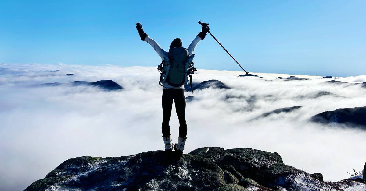 hiker on top of mountain in winter