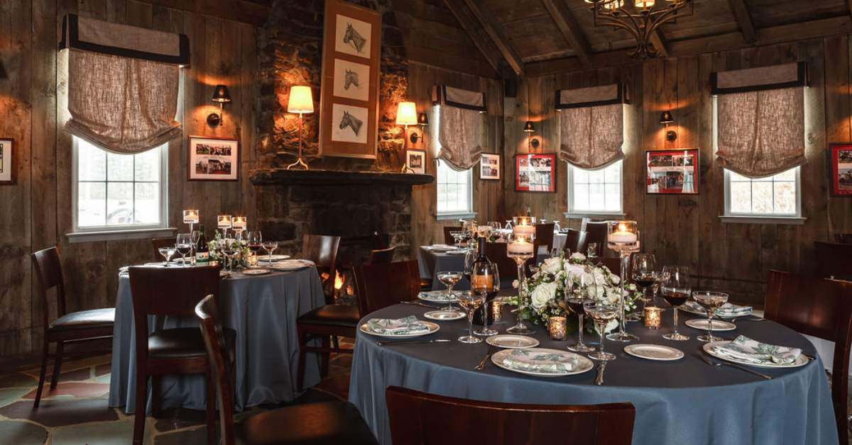 three tables set up with tableware and candles in a rustic restaurant