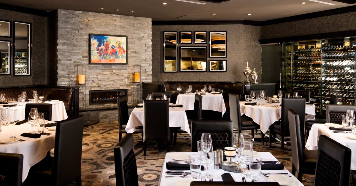 a restaurant dining room with tables, chairs, and a fireplace