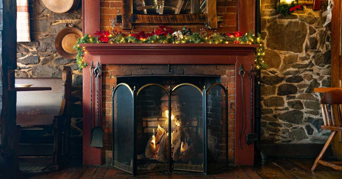 fireplace with garland and lights on the mantle