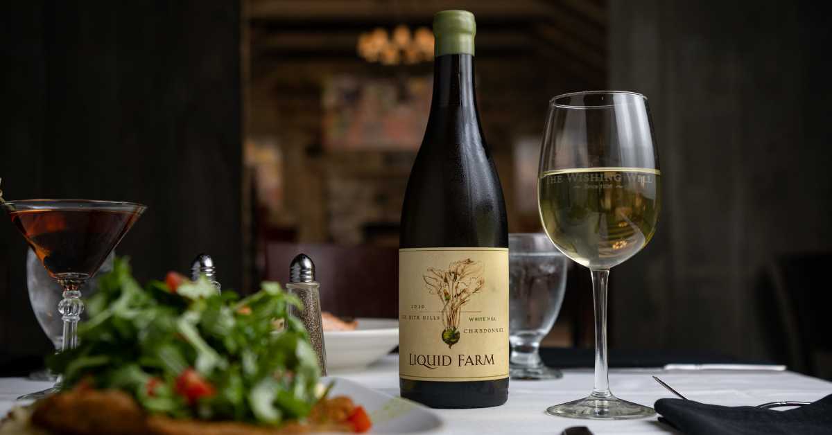 wine bottle, glasses, and food on a table