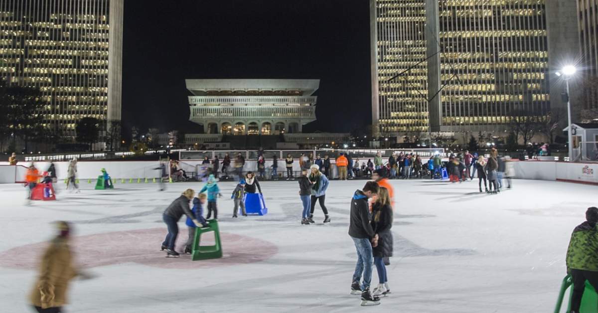 people ice skating outdoors at night