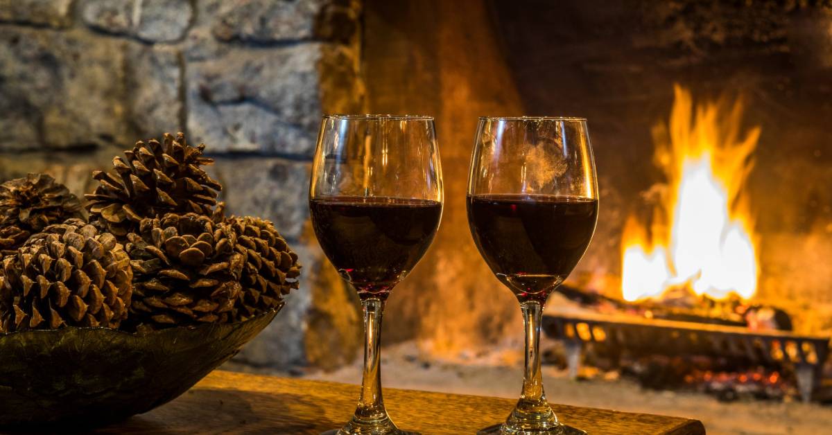 wine glasses in front of roaring fire