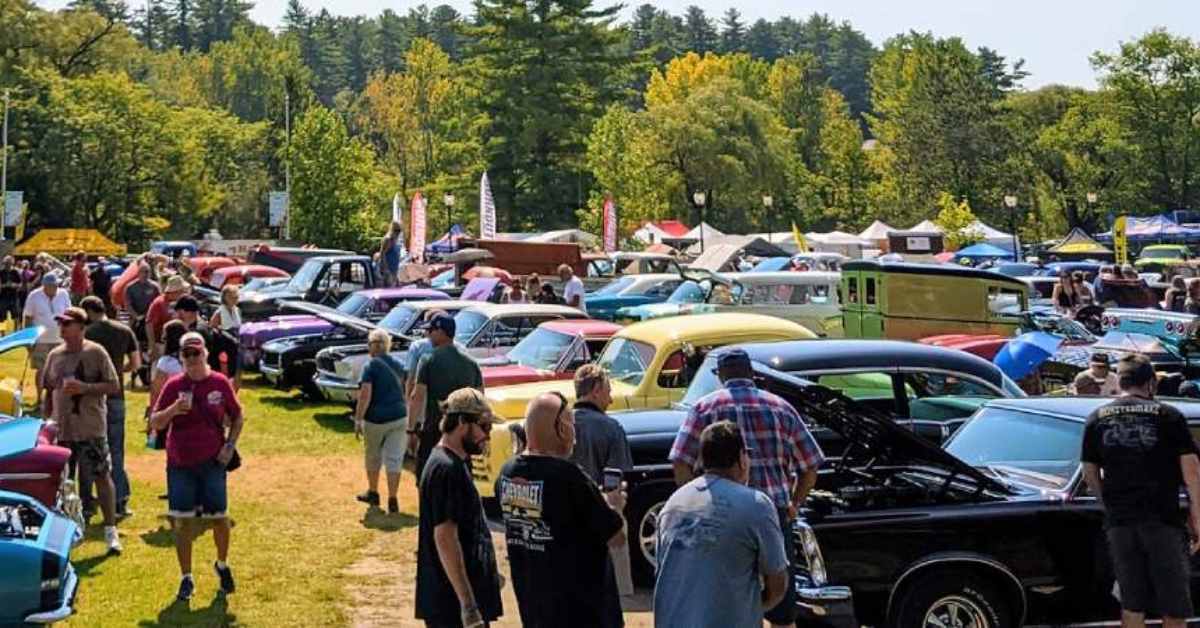 people walking around a large outdoor car show