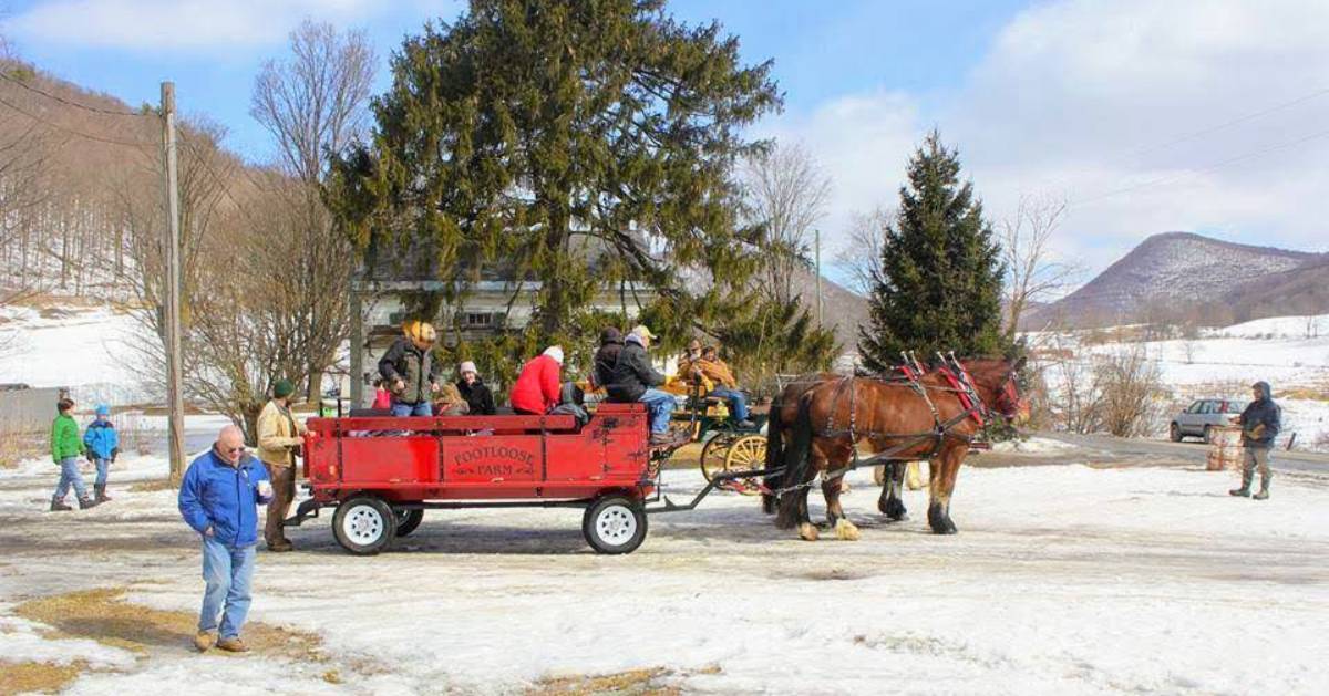 people on a red horse drawn wagon.