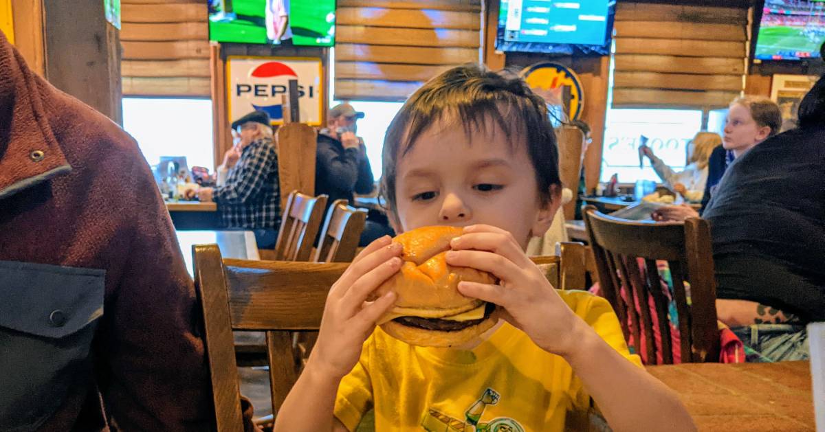 kid about to bite into a burger