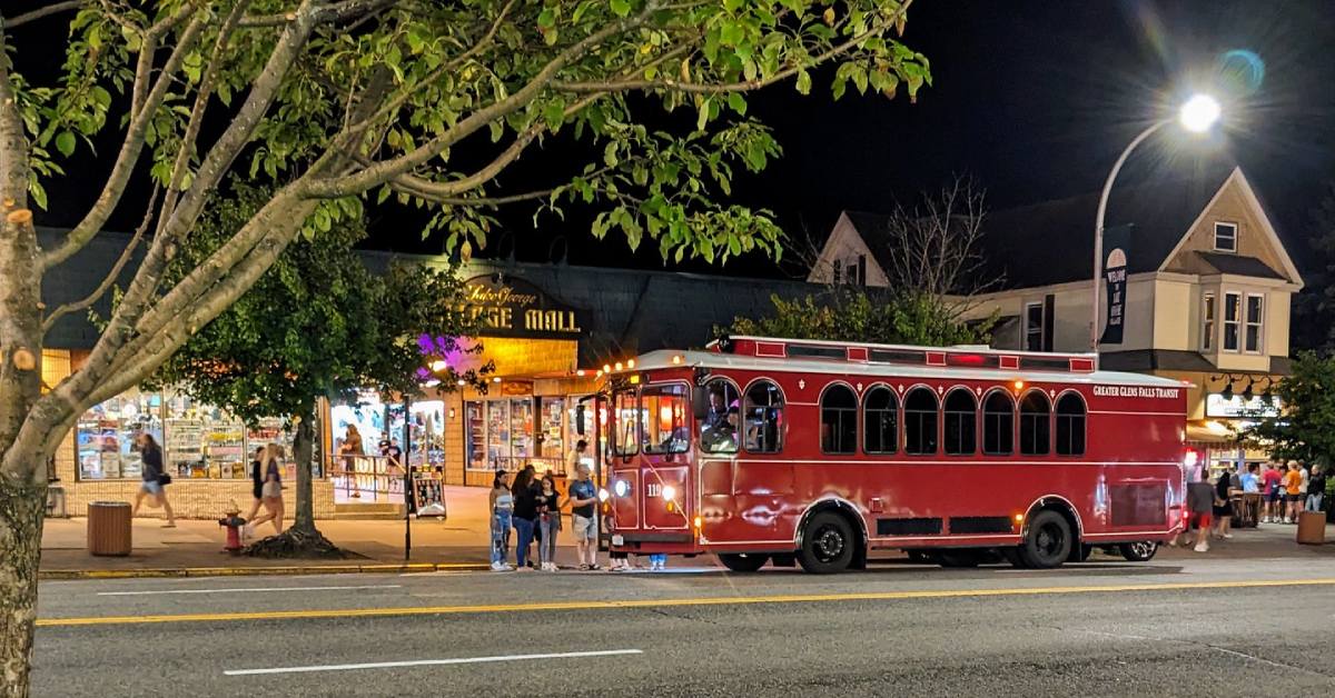 red trolley in front of lake george village mall