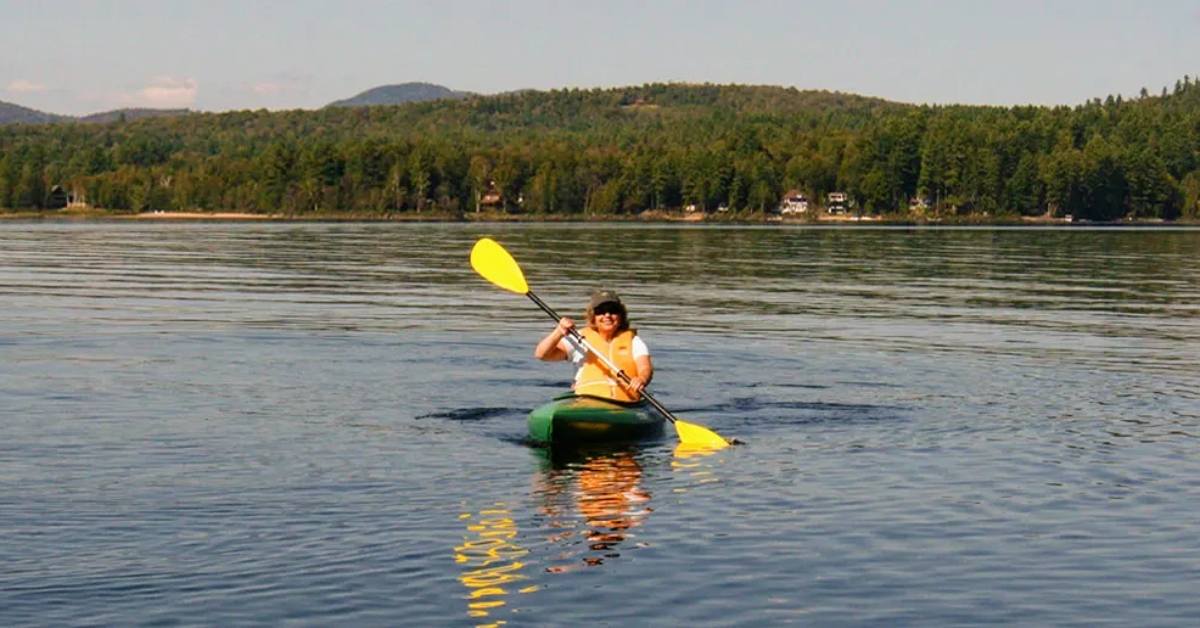 woman kayaks on long lake