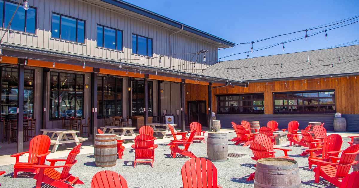 red Adirondack chairs near picnic tables and a brewpub
