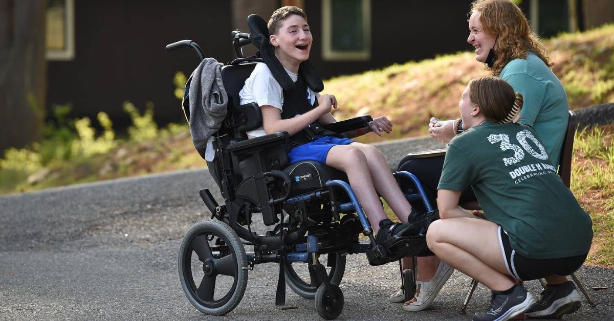 camp kids, one is in a wheelchair, laughing