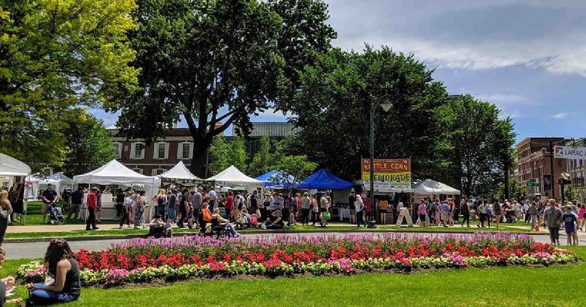 glens falls city park with flowers and a festival with tents set up for vendors