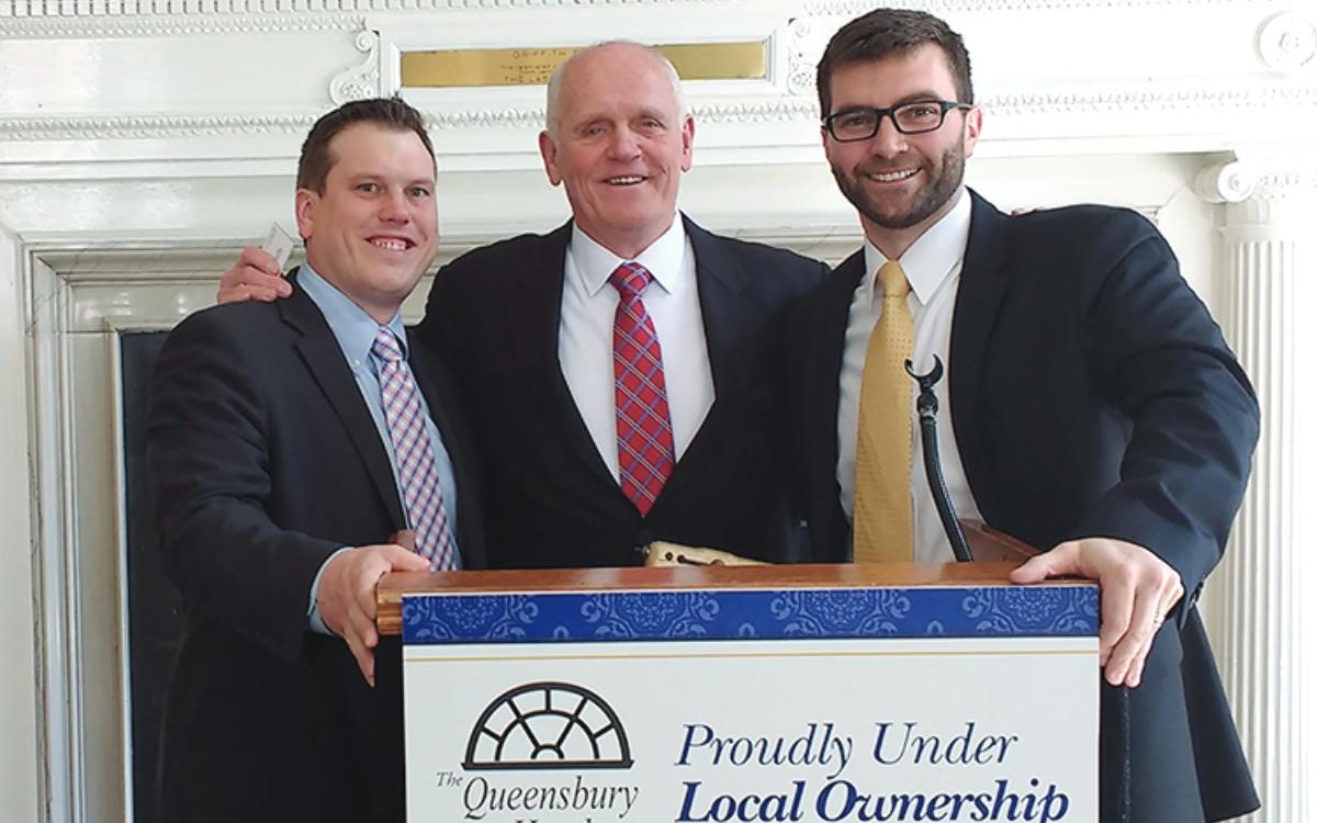 three men standing at a podium