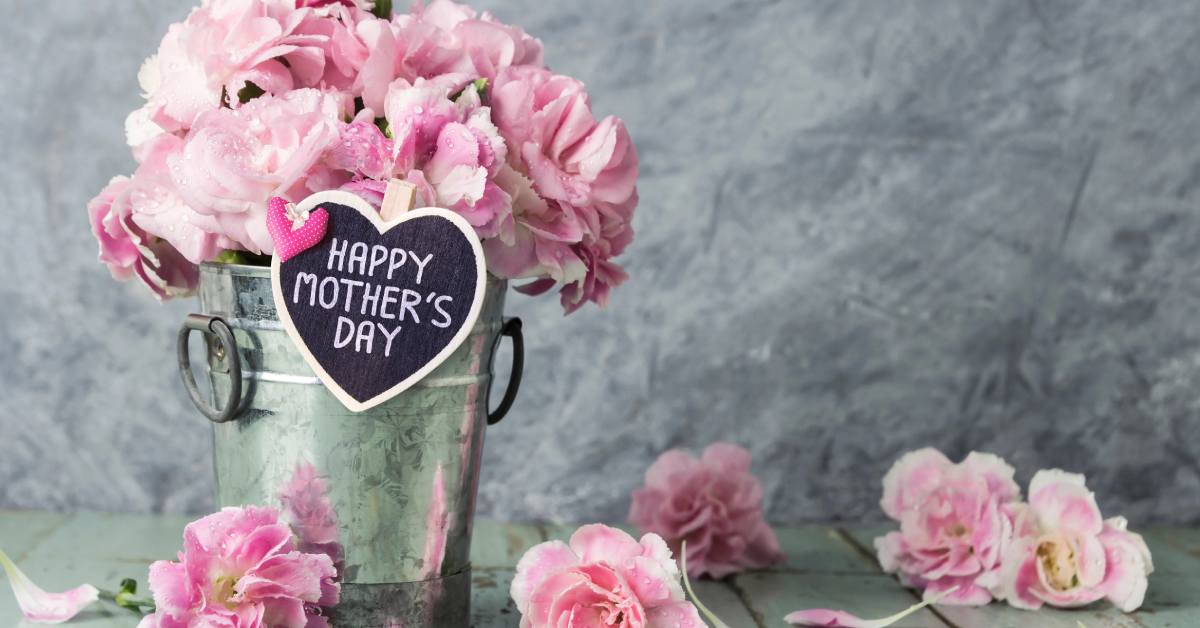 mother's day sign with pink flowers and bucket