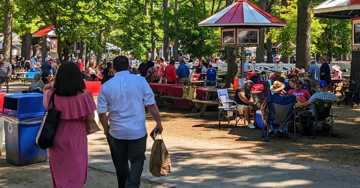 back of couple walking towards picnic area at saratoga race course