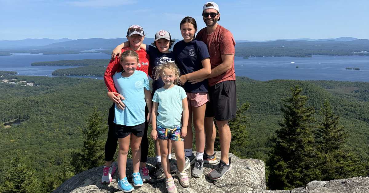 a family standing together for a photo on a rocky summit