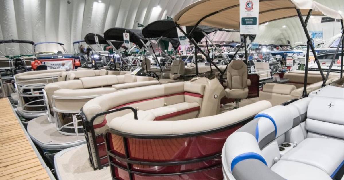 Pontoon boats lined up next to a fake dock in a dome building