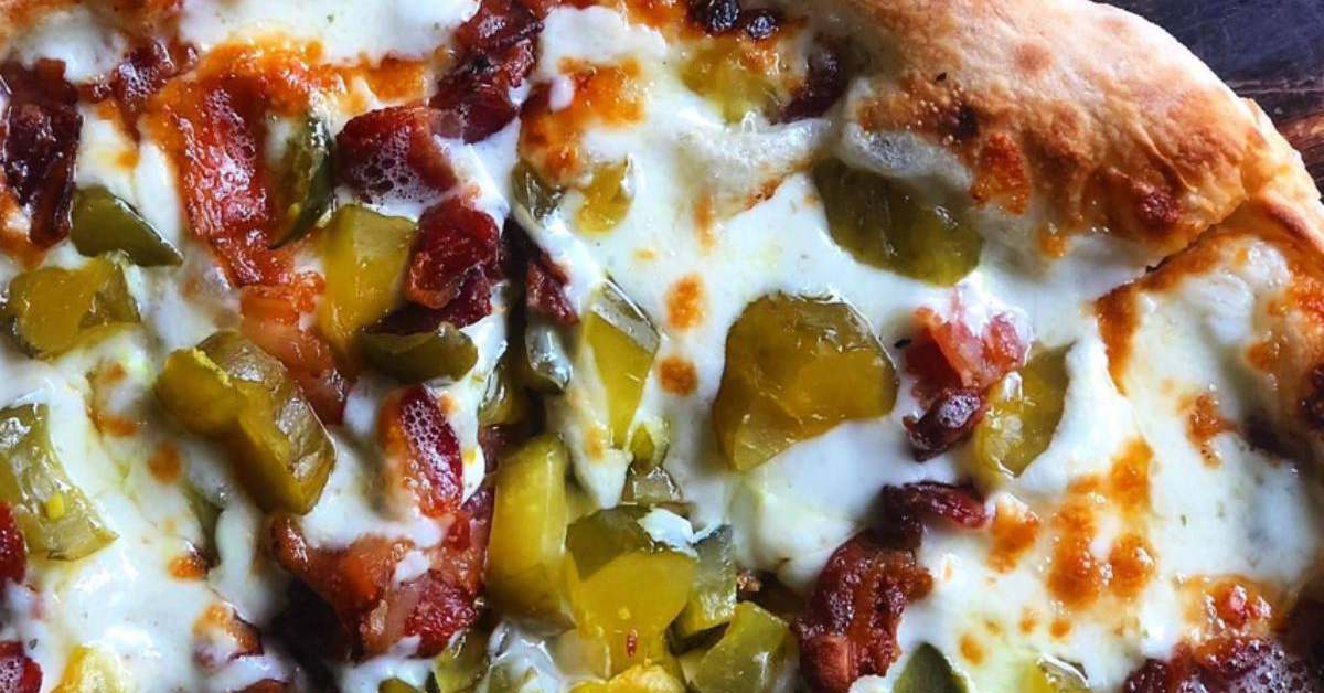 pickles and bacon on a pizza