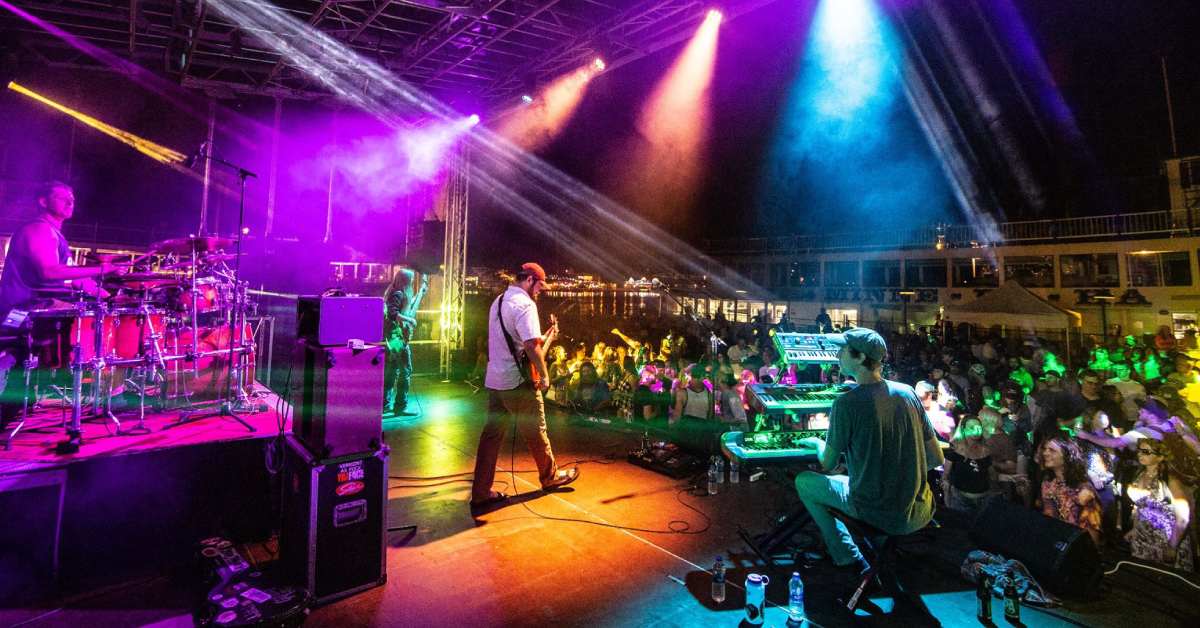 Band playing on stage under colorful lights in front of audience