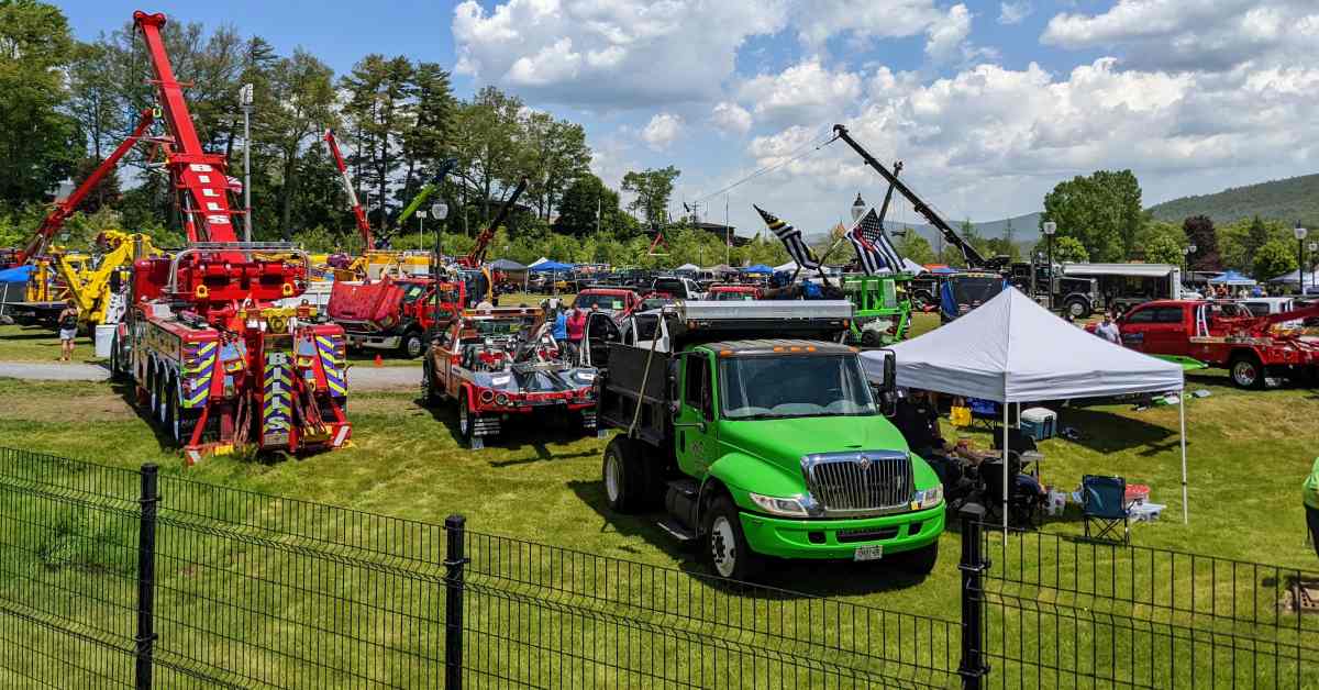 Various tow trucks parked in a fenced in park