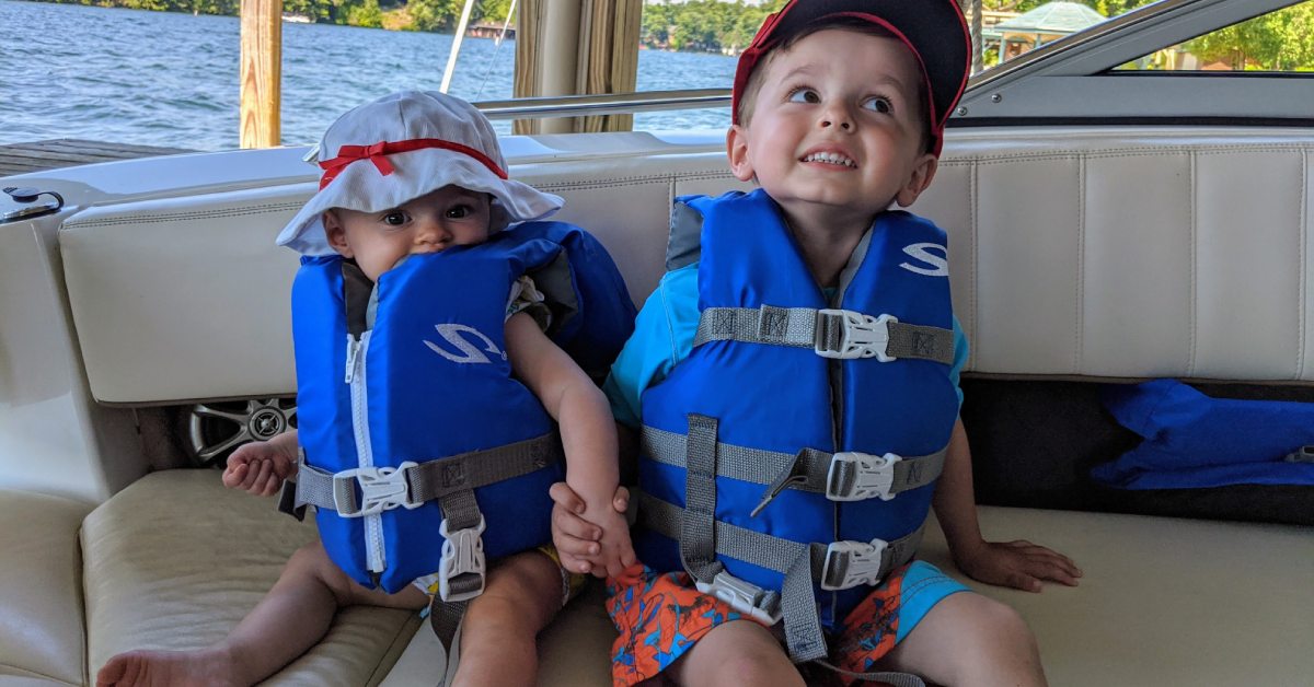 baby girl and toddler boy on boat with lifejackets