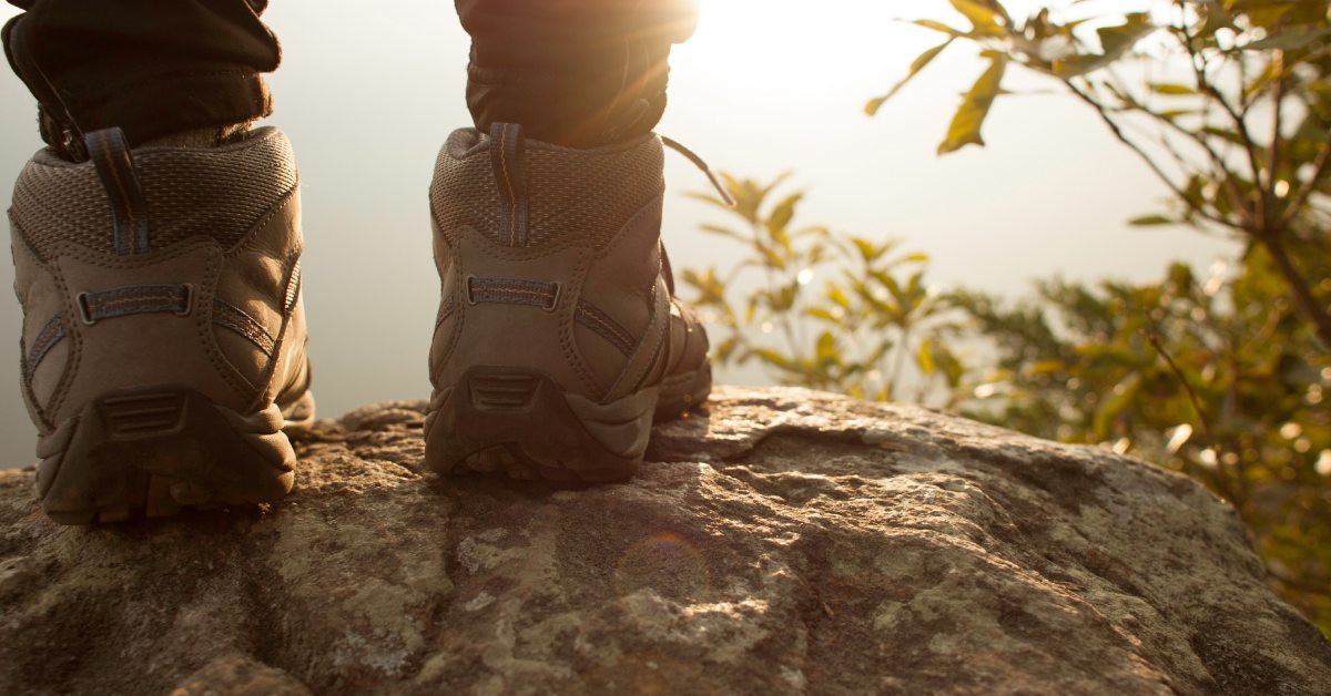 closeup of hiker wearing boots and long pants standing on rock