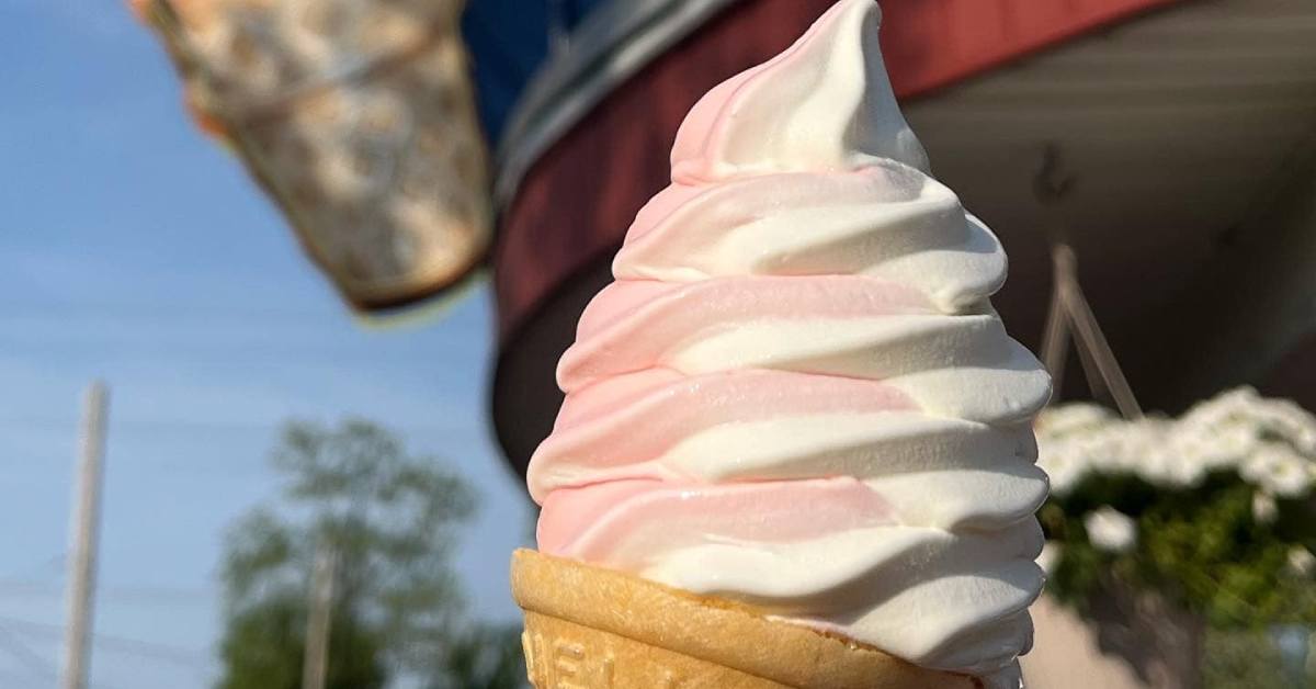 close up of light pink and white swirl ice cream cone