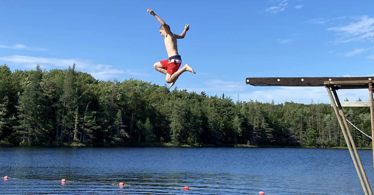 camper kid jumps in lake