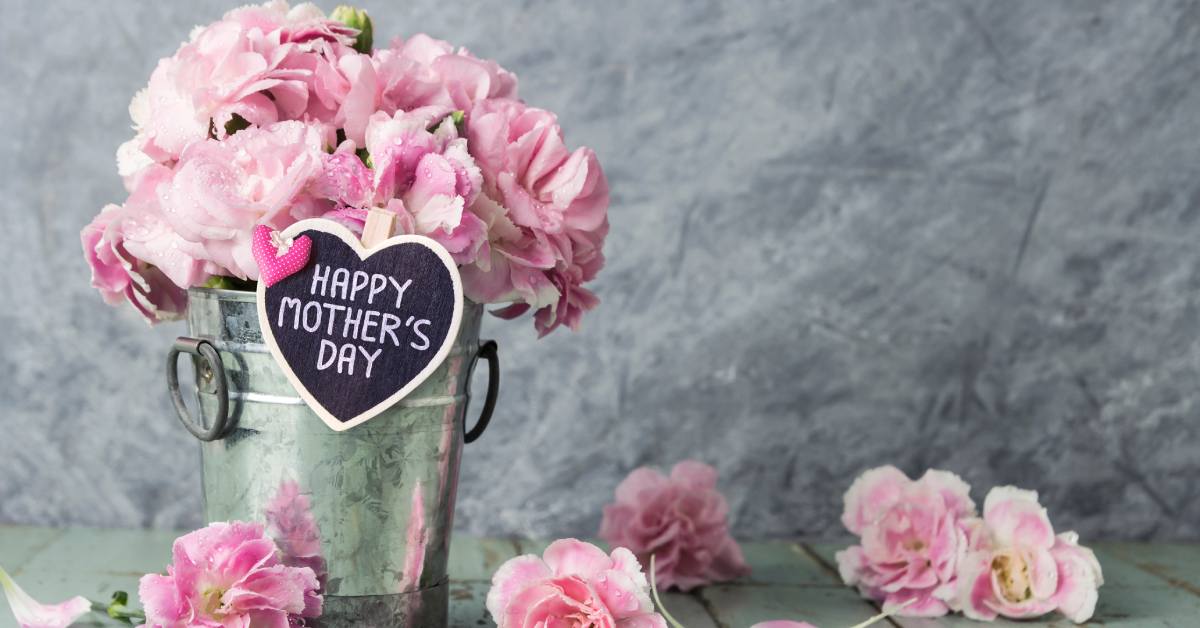 bucket with pink flowers and a happy mother's day sign