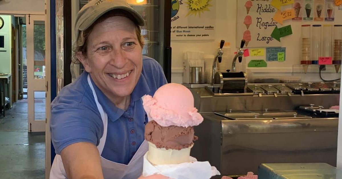 woman holds out ice cream cone