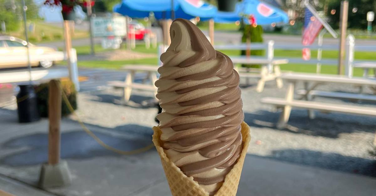 chocolate and vanilla twist in a cone with picnic area in background