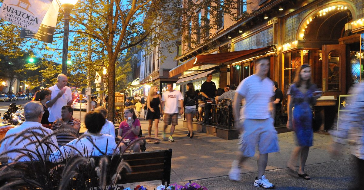 people on broadway in saratoga at dusk