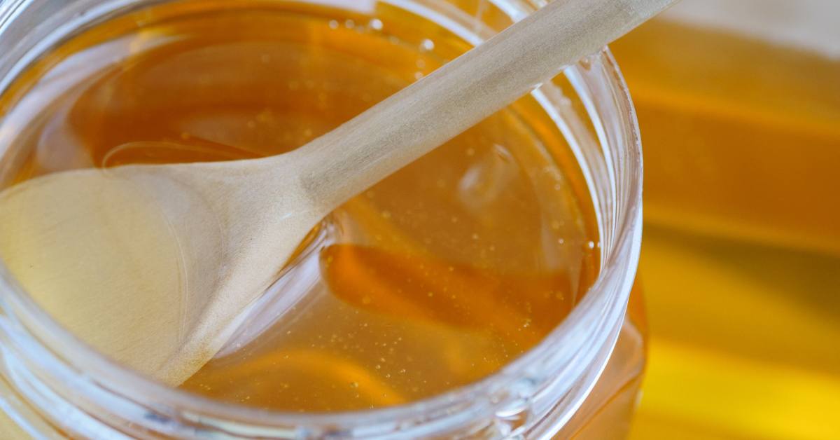 spoon in jar of raw honey