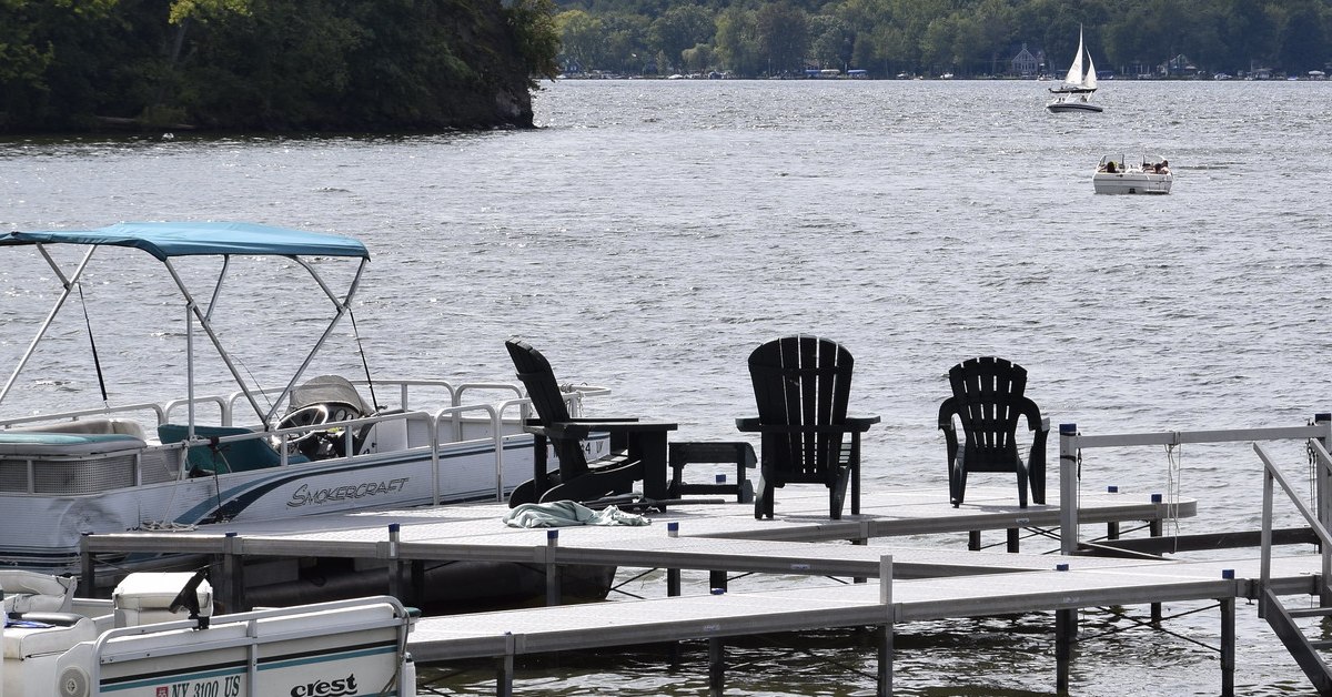 dock on saratoga lake with boats and adirondack chairs
