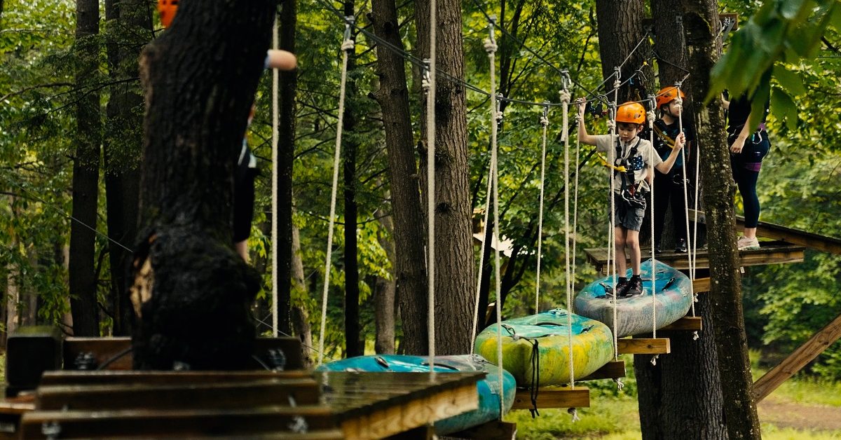 kids on treetop course with kayaks as part of a bridge