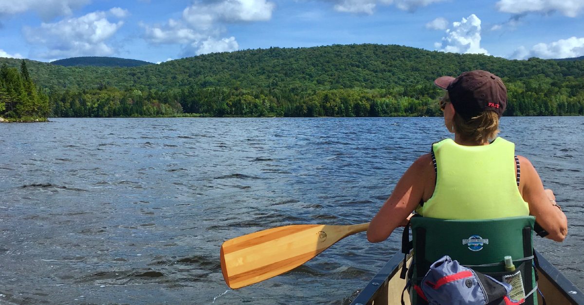 woman kayaks on adirondack lake