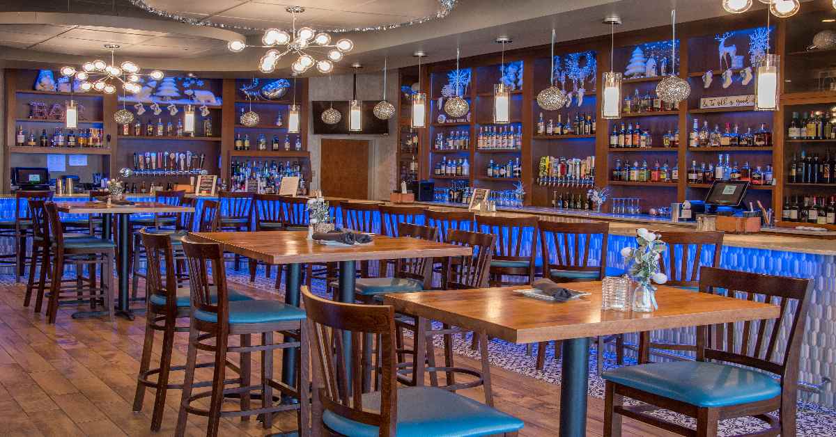 Interior of a restaurant with wooden tables and blue ambience lighting