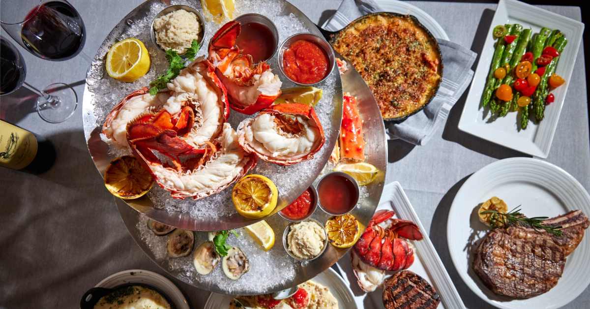 Table with seafood, steak, and veggies on it