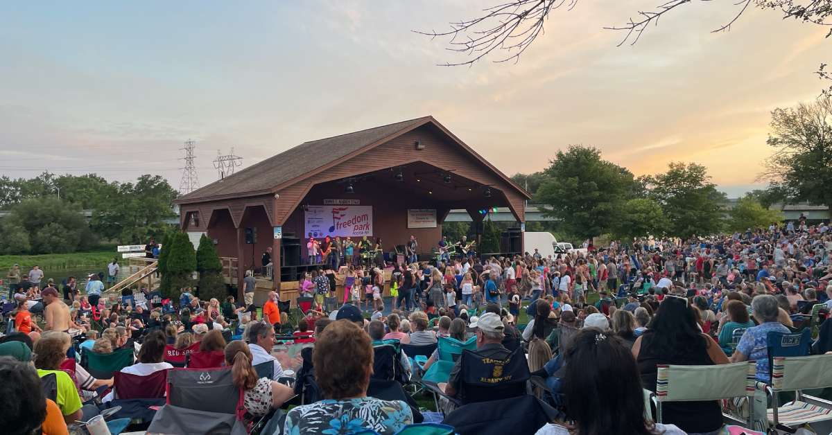 crowd of people watching a concert at an outdoor amphitheater
