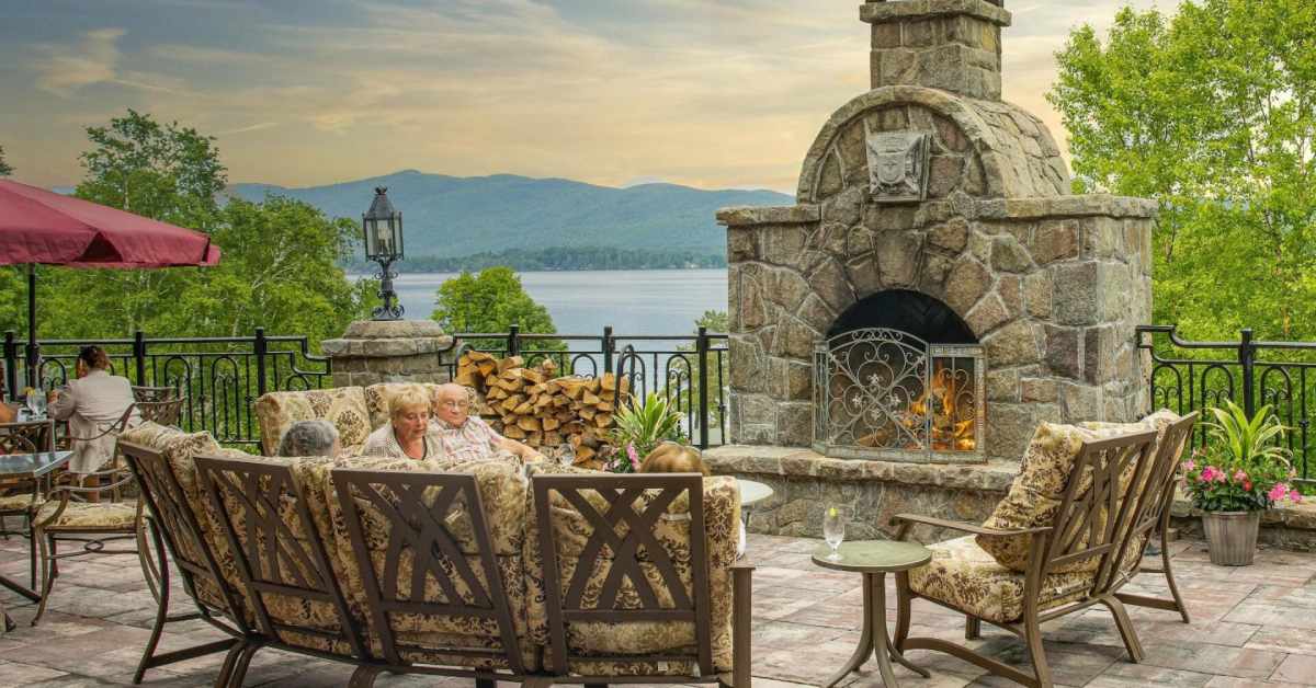 Patio with couches and a firepit with a lake in the background