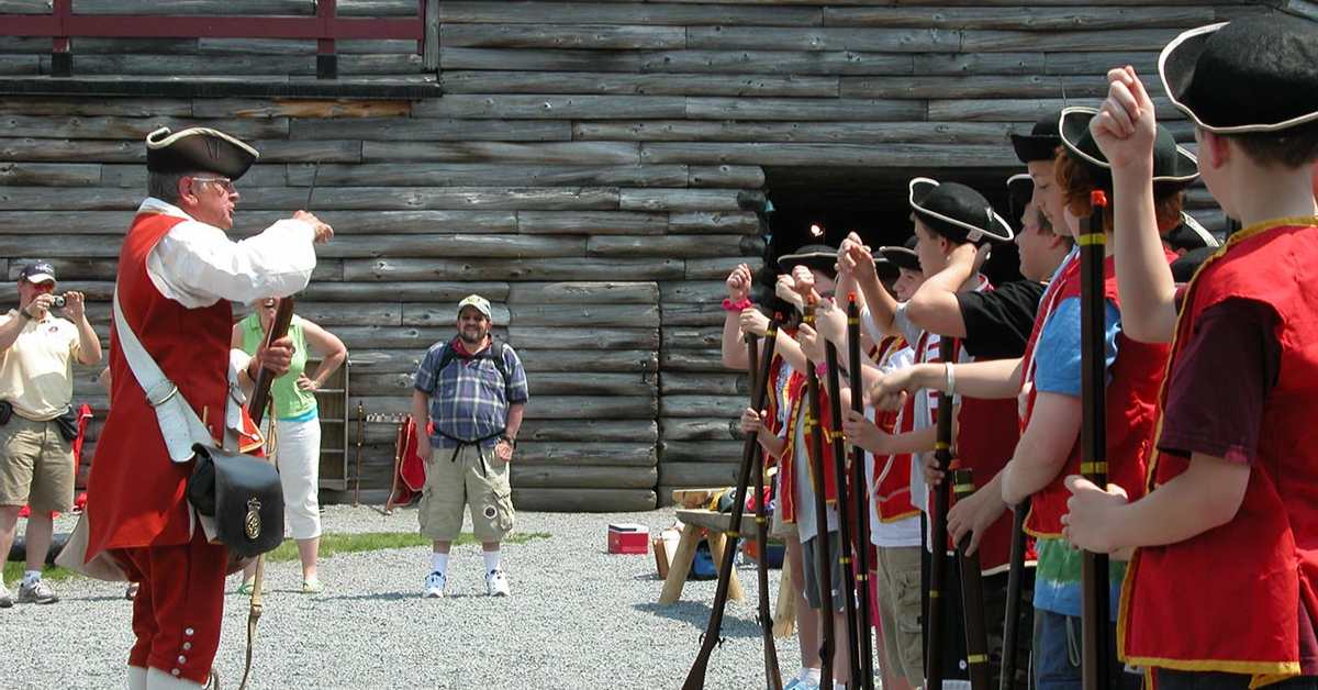 Kids and reenactor dressed up at a historic fort museum