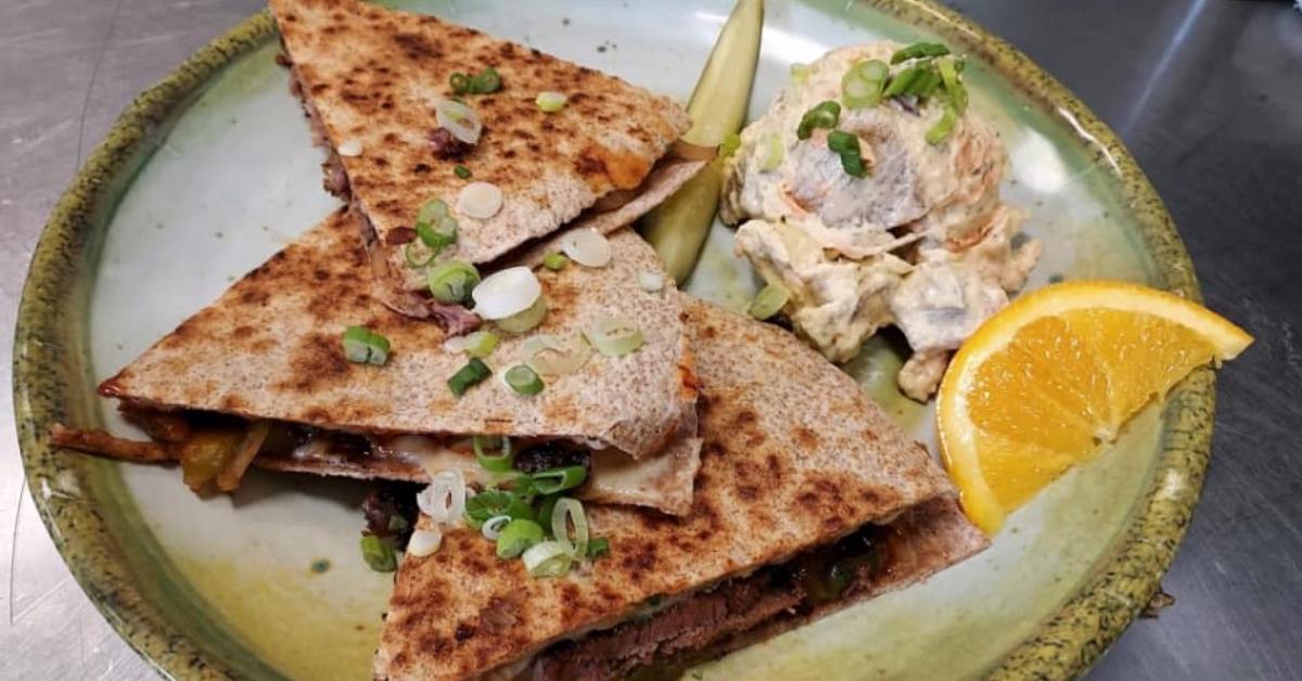 Plate of quesadillas with a lemon, pickle and other sides
