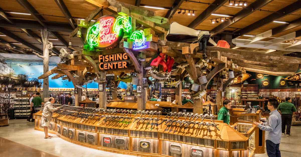 inside of Bass Pro Shops at the fishing center with customers checking out fishing rods