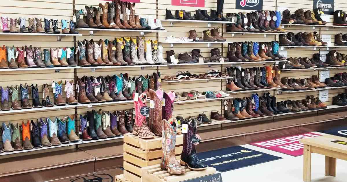 different types of shoes, mostly cowboy boots, lining the wall