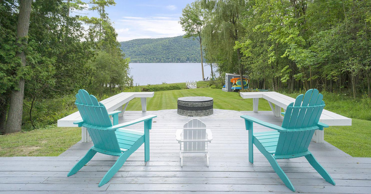 teal Adirondack chairs facing lake