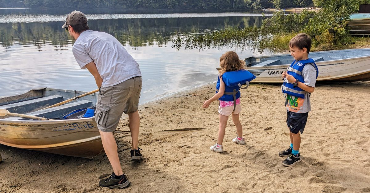 a dad with son and daughter going into a rowboat