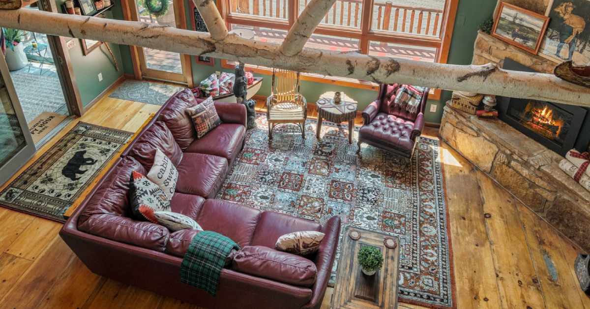 aerial view of a rustic living room with furniture and a fireplace